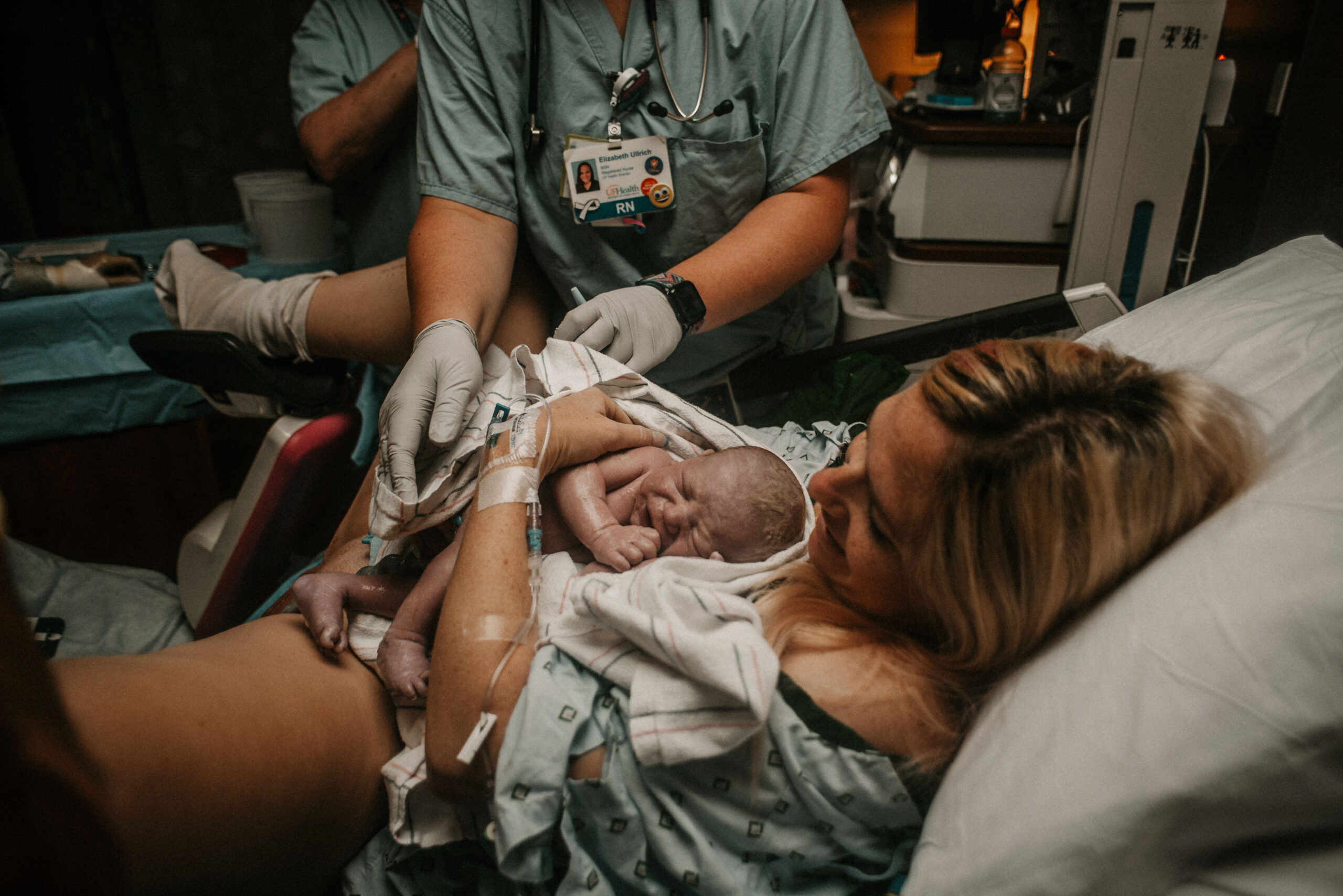 Mother holding her newborn immediately after delivery during a hospital birth in Ocala, Florida, supported by medical staff and documented by Savannah A. Photography, birth photographer and doula.